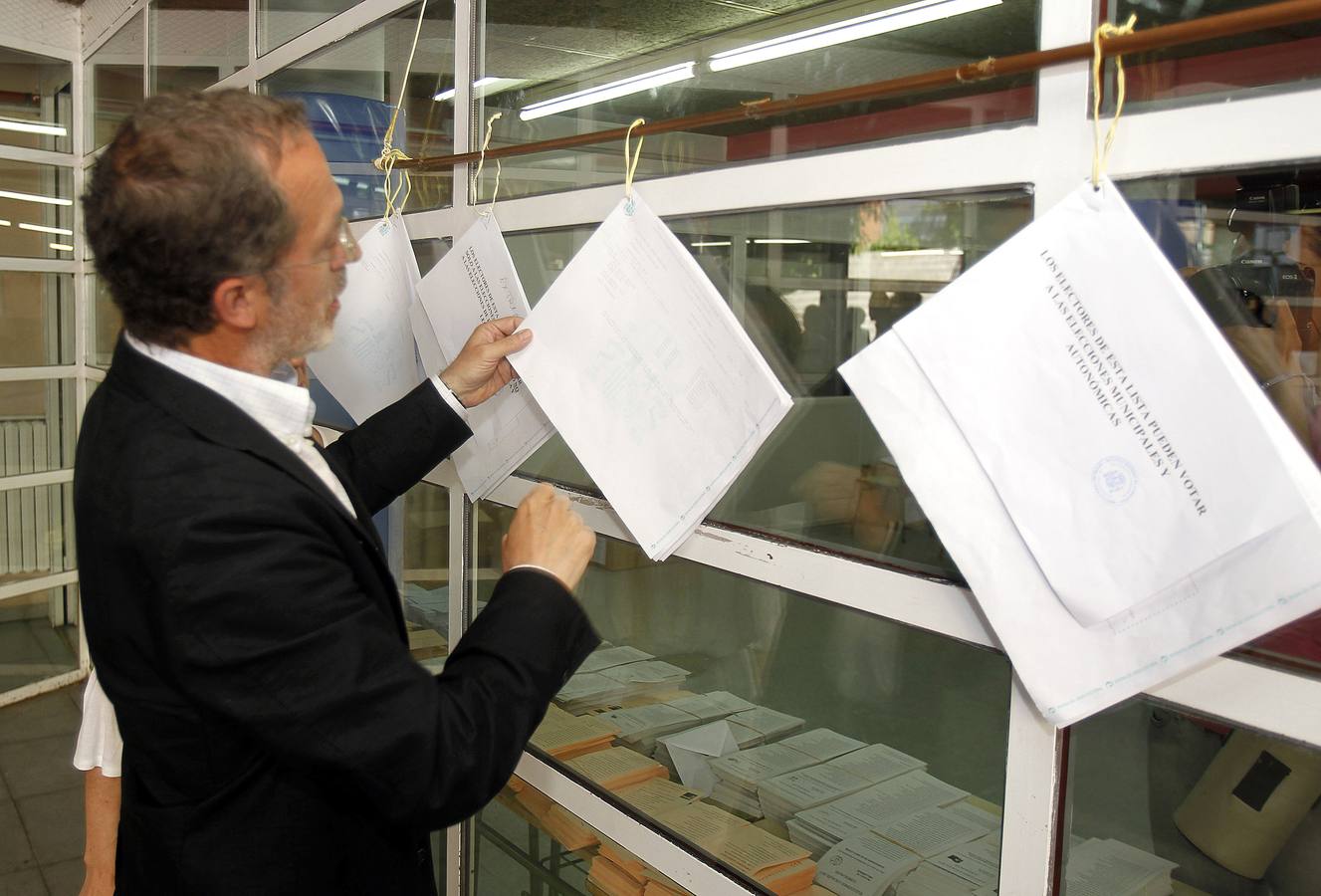 Manuel Saravia, candidato de IU a la Alcaldía de Valladolid, mira las listas electorales para poder votar.