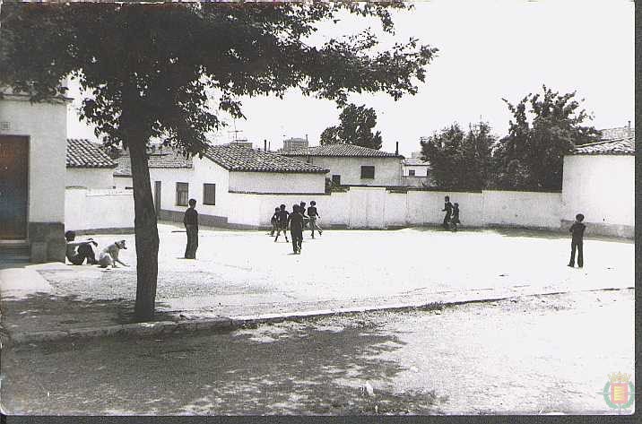 Plaza del barrio con niños jugando en los años 70.