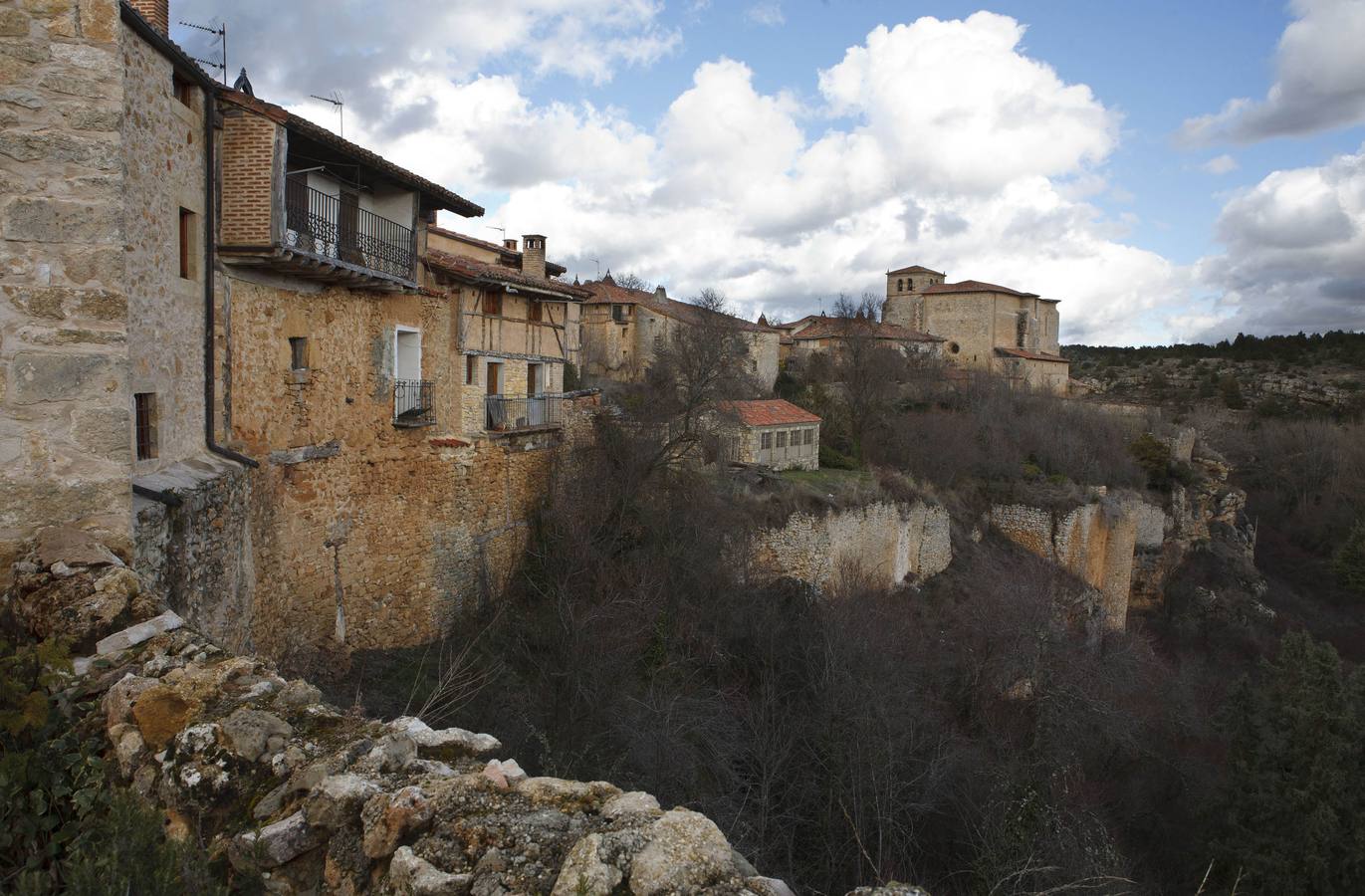 Calatañazor (Soria). Pueblo amurallado que en su parte más alta contempla el castillo. Desde su Torre del Homenaje se divisa todo el valle. Las construcciones se aglutinan en torno a su calle principal, porticada, que llegaba hasta la plaza de Armas, luego Plaza Urbana; donde se observan construcciones típicas de Tierra de Pinares, creadas con madera, barro y piedra.