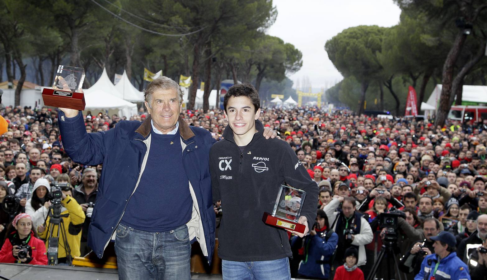 2011. Giacomo Agostini y Marc Márquez, con sus 'Pinguinos de Oro', ante una multitud que siguio la clausura de la concentración motera.