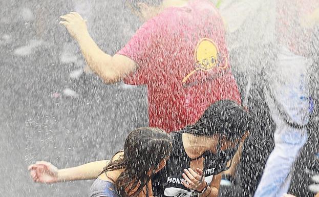 Dos jóvenes disfrutan del desfile de peñas, uno de los actos más multitudinarios de las ferias.