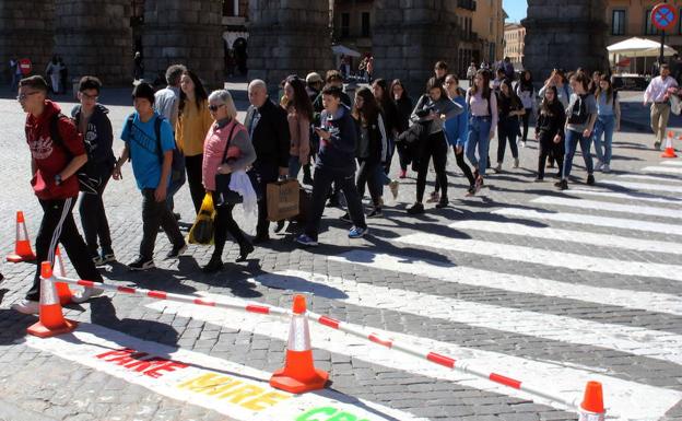 Transeúntes atraviesan el paso de la plaza de Artillería que luce el aviso tricolor. 