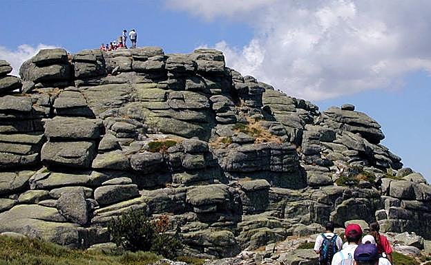 Varias personas coronan las piedras que configuran los picachos de Siete Picos. 