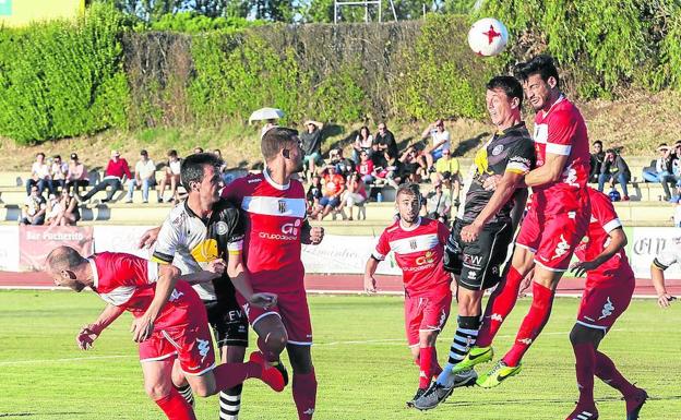 Óskar Martín intenta rematar de cabeza ante la oposición de un jugador del Mérida AD.