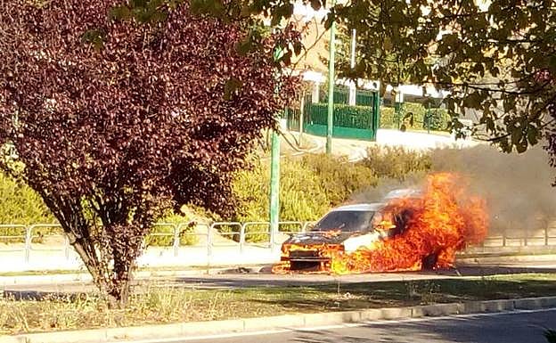 El coche incendiado en llamas. 