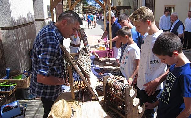 Unos niños revisan uno de los puestos del mercado.