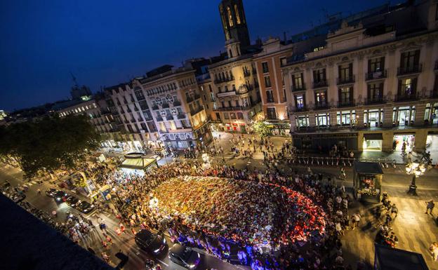 Centenares de personas cantan homenajeando a las víctimas en el mosaico de Joan Miró de las Ramblas, después de participar en la manifestación contra los atentados yihadistas en Cataluña.