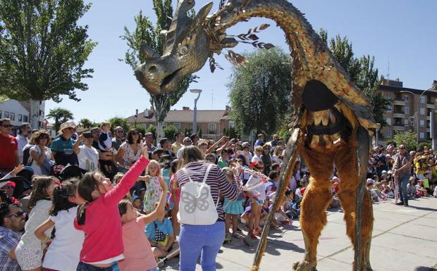 Un grupo de niñas intenta tocar la cabeza de uno de los personajes que ayer desfilaron en el pasacalles.