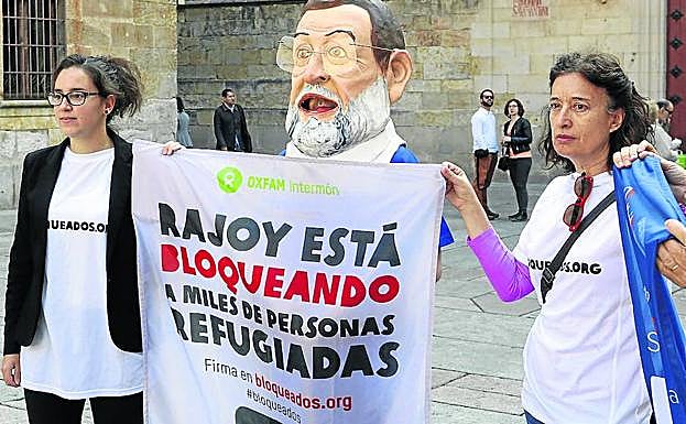 Voluntarias de Intermón y ‘Rajoy’ sujetan una de las pancartas de la campaña.