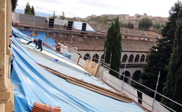 Obreros trabajando sobre el tejado del muro norte del Monasterio del Parral. 