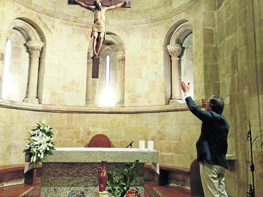 José María Miñambres, frente al Cristo del altar en el iglesia de San JuanBautista. 