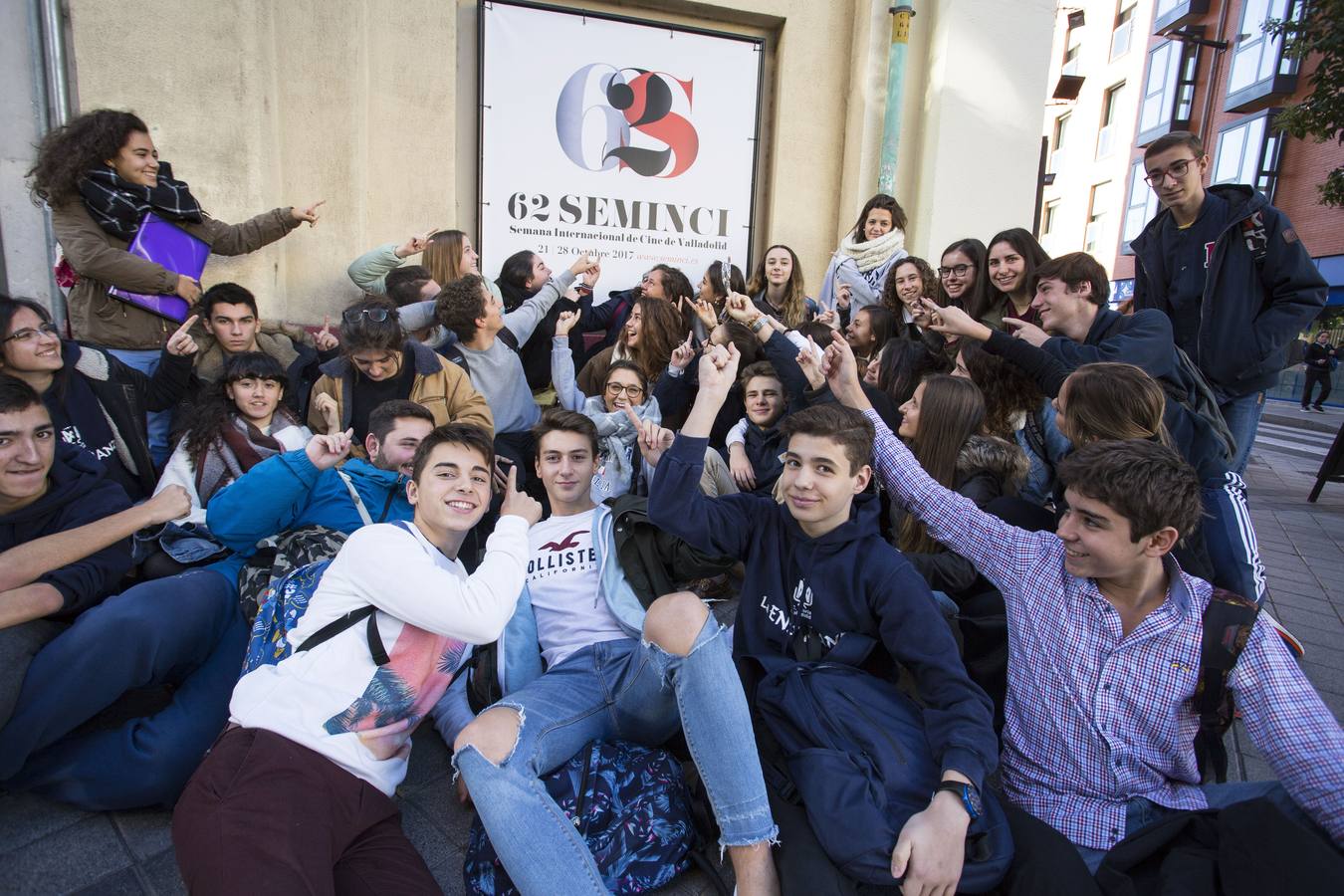 Un grupo del colegio Compañía de María La Enseñanza señala el cartel de la 62 edición de la Seminci, en un lateral del teatro Cervantes.