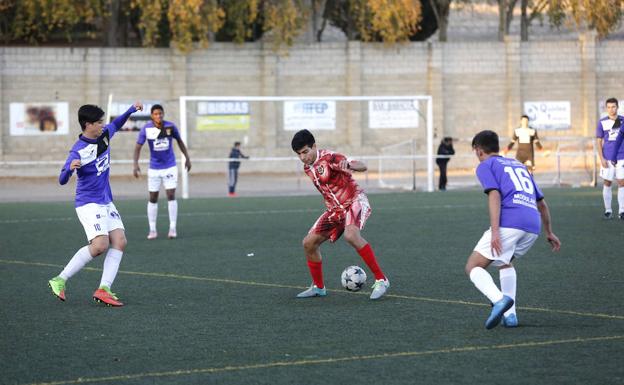 El jugador del CD Palencia controla el balón ante dos rivales del Palencia 1929. 