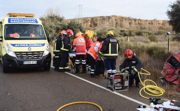 Bomberos y sanitarios atienden al hombre en el lugar del accidente.