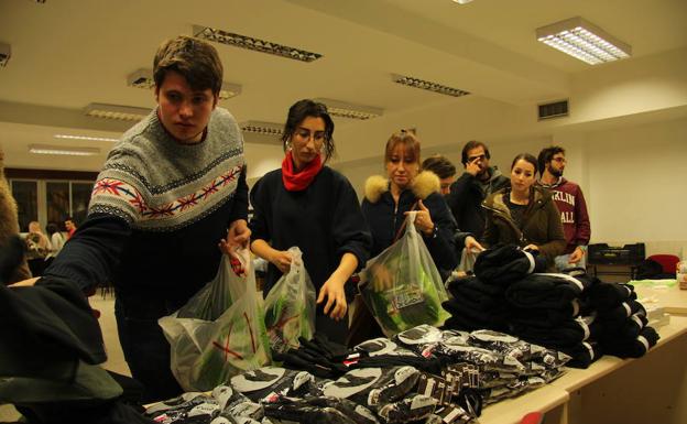 Varios voluntarios preparan los kits de ropa de abrigo antes del reparto por la ciudad.