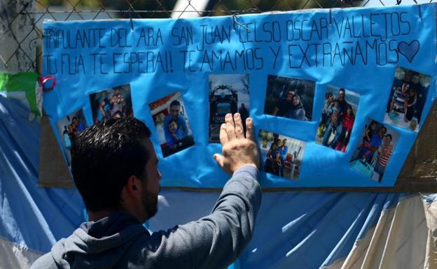 Un familiar de uno de los tripulantes del 'San Juan', ante un cartel.