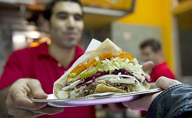 Un camarero sirve un kebab en un restaurante turco
