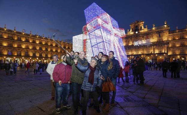 Un grupo de personas se hace un selfi junto al adorno navideño.