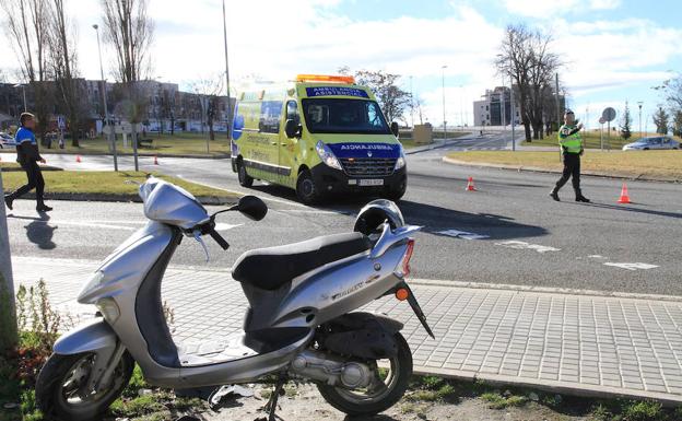 La ambulancia y agentes de la Policía Local atienden el accidente junto a la moto implicada. 