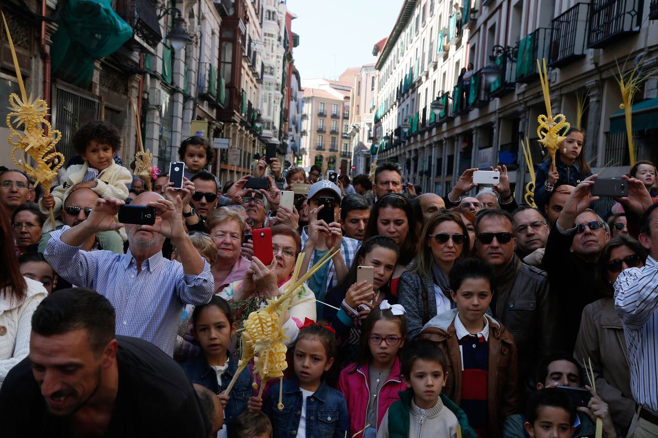 10.04 Los espectadores fotografían con sus teléfonos móviles el paso de la Borriquilla a su salida de la iglesia de la Vera Cruz.