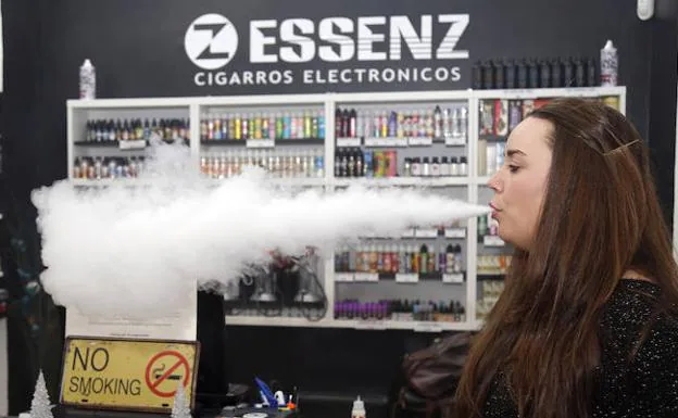 La dueña de la tienda de cigarros electrónicos de Palencia, Jessica Rojo, vapea en su local. 
