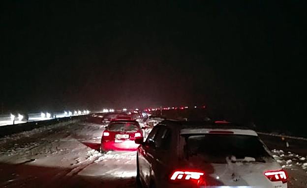 Varios conductores intentan circular por la AP-6 entre Segovia y Madrid tras una intensa nevada. 