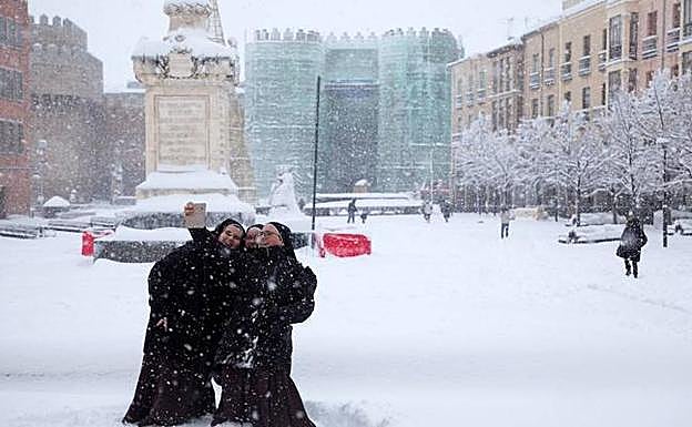 Tres monjas se hacen un selfi en el Mercado Grande de Ávila durante la nevada que cubre la ciudad.. Raúl Sanchidrián