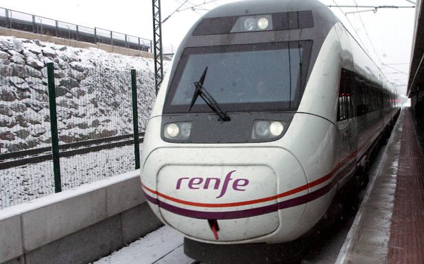 Tren parado en la estación del Ave de Segovia con los alrededores nevados. 