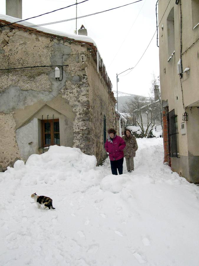 2006. Dos mujeres caminan por una calle de Collado Hermoso, totalmente cubierta de nieve.