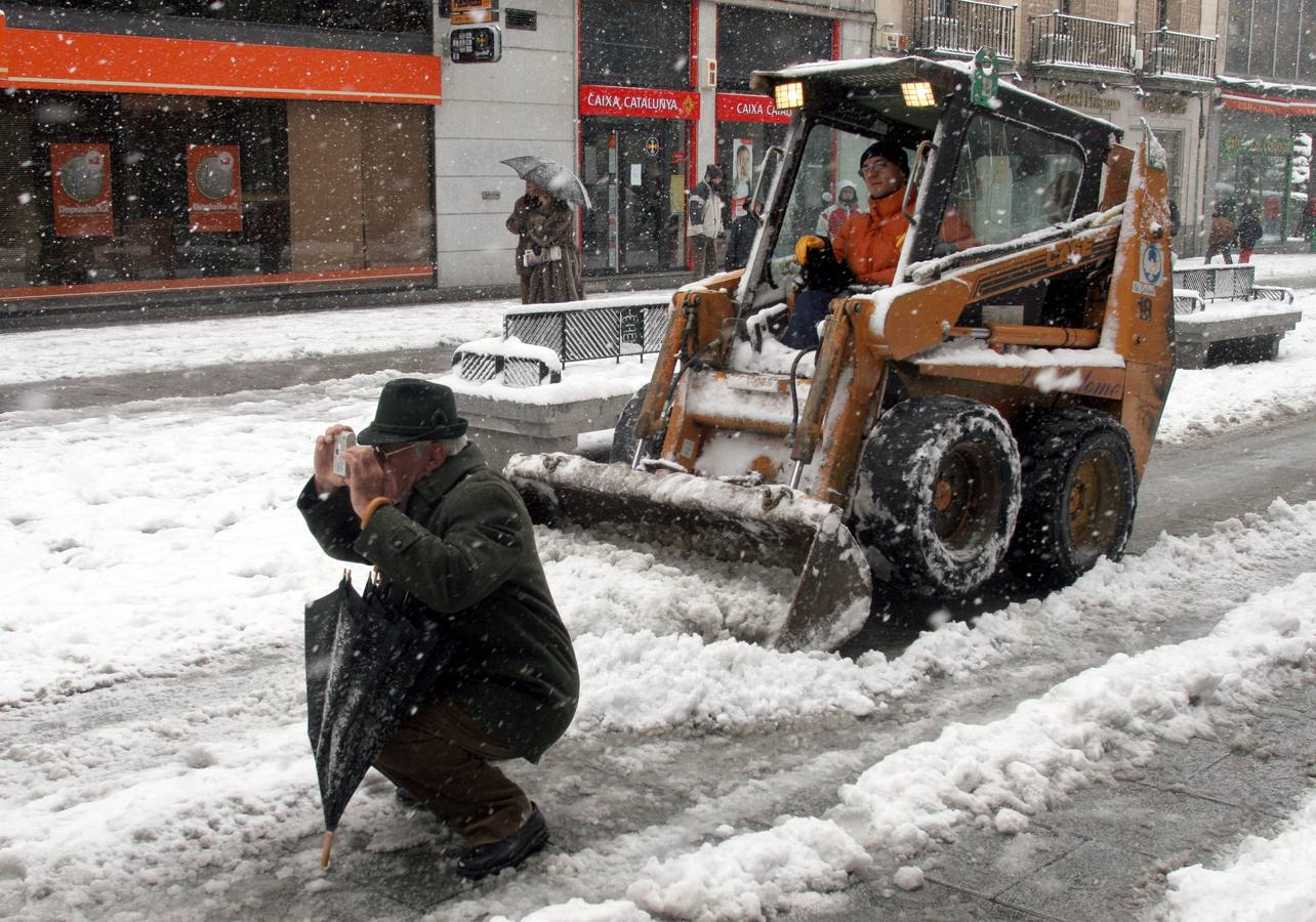2006. Una minipala frena cuando un hombre se cruza para sacar una foto de la nieve.