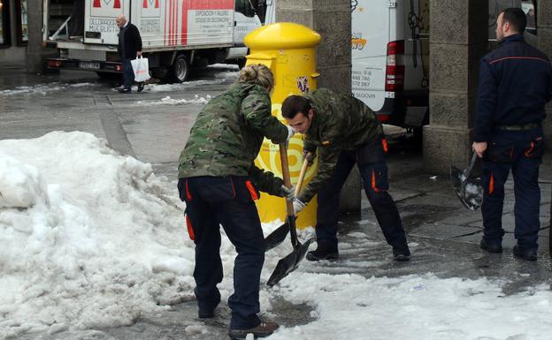 Dos militares retiran la nieva a paladas, este miércoles en el Azoguejo. 