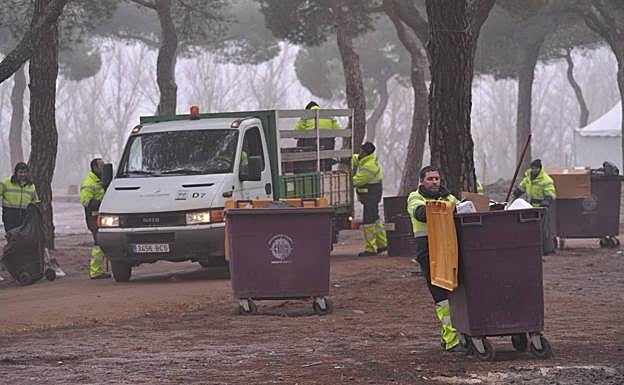 Los operarios retiran la basura de la zona de acampada. 