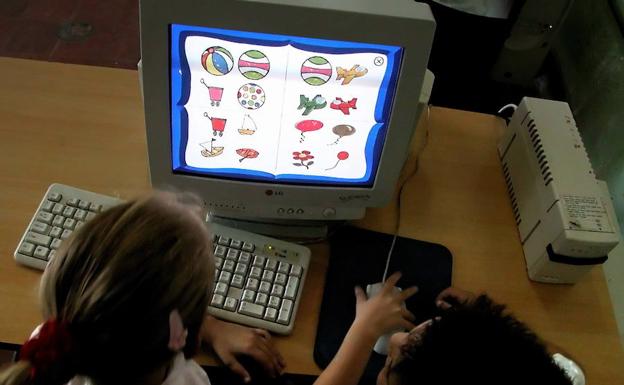 Unos niños estudian con un ordenador. 