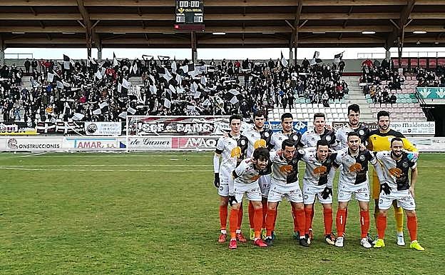 El once inicial de Unionistas en Zamora posa delante de la grada en la que estaba situada la afición salmantina. 