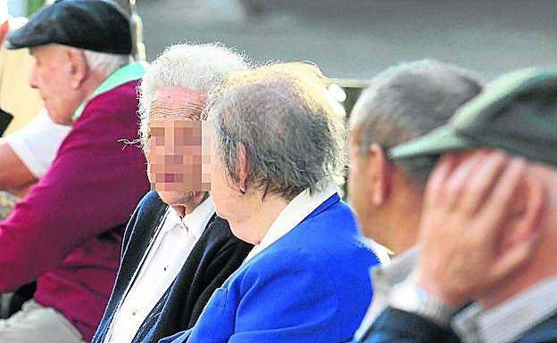 Un grupo de jubilados conversan sentados en una céntrica calle de Segovia. 