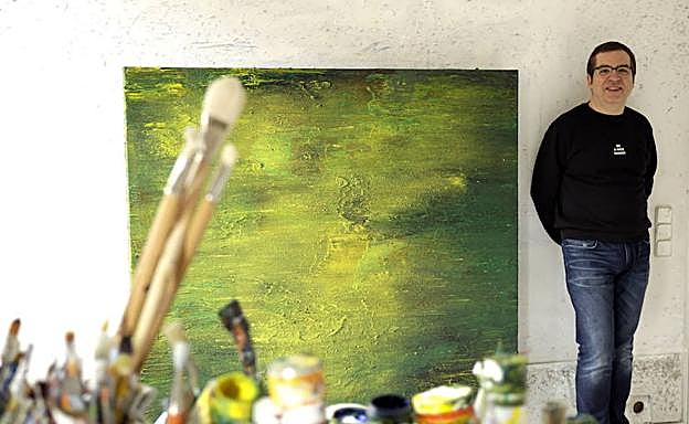 Alberto Reguera, en su estudio junto a una de sus obras pictóricas. 