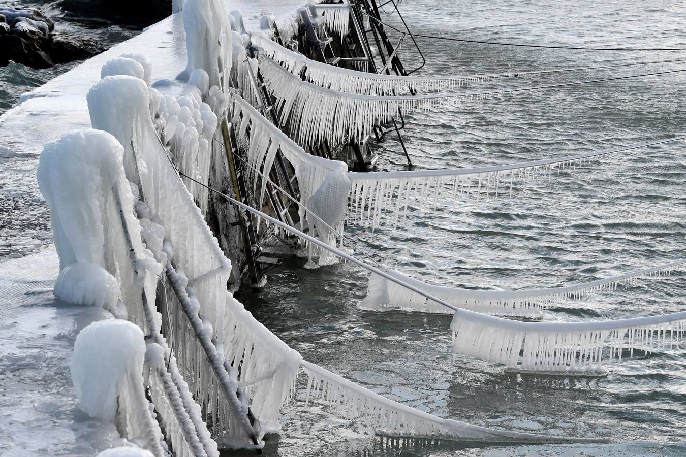 Carámbanos de hielo cubren los amarres de los barcos en el lago de Constanza, en Suiza.