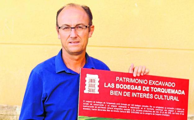 El alcalde de Torquemada luce un cartel sobre las bodegas, declaradas bien de interés cultural. 