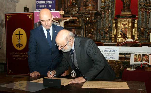 Paulino Galván (derecha) firma el hermanamiento por parte de la Semana Santa de Benavente ante la mirada de José Luis Herrero, presidente de la Junta de Cofradías de Cuéllar. 