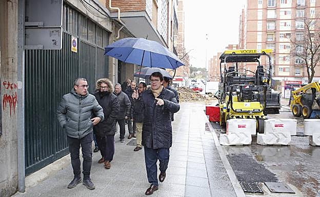 El alcalde se protege con un paraguas de la lluvia durante su visita al barrio Garrido. 