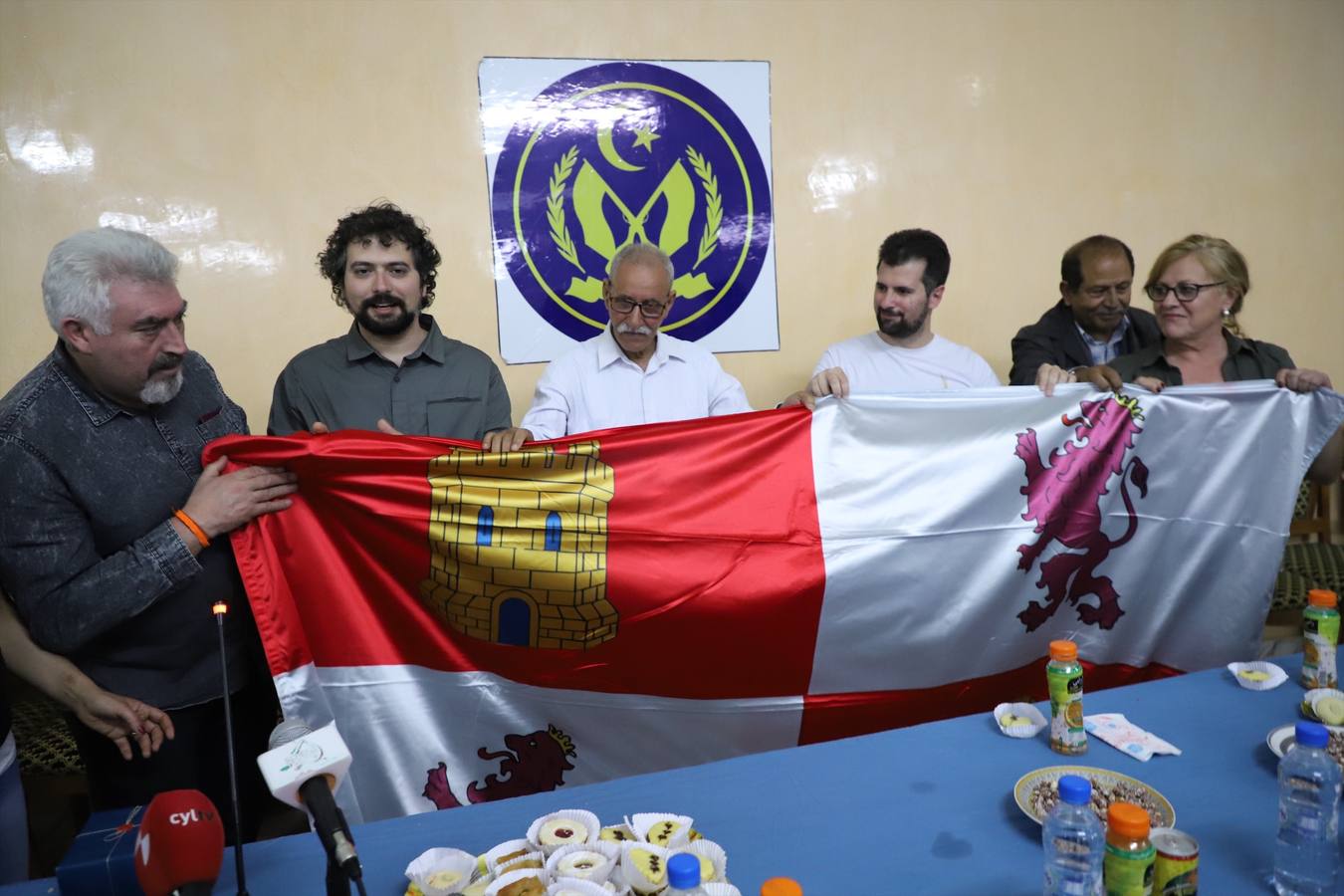 El presidente de la la RASD Brahim Ghali recibe a la delegación de CyL en los campos de refugiados. En la imagen despliega la bandera de CyL que le regala la delegación.