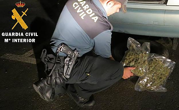 Un agente, con unas bolsas de cannabis. 