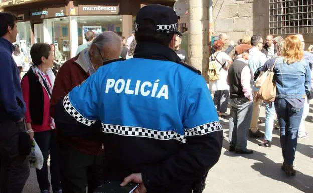 Un policía local observa una concentración de gente en una céntrica calle de Segovia. 