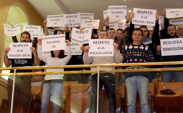 Policías locales muestran carteles de protesta durante el pleno. Antonio de Torre