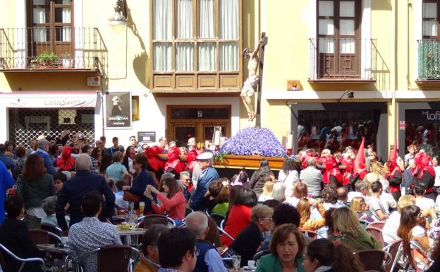 Terrazas llenas ante el paso de una procesión. 