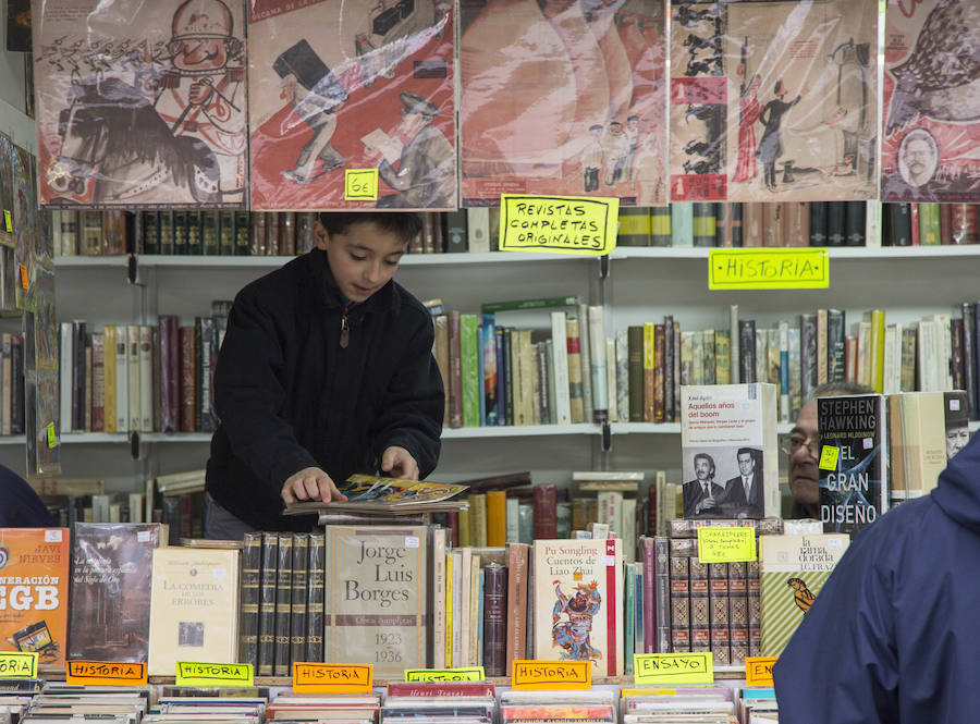 Un niño mira unas revistas antiguas en uno de los puestos. 