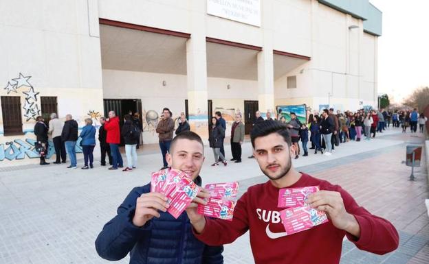 Dos jóvenes aficionados sujetan varias entradas para el partido de Avenida. 