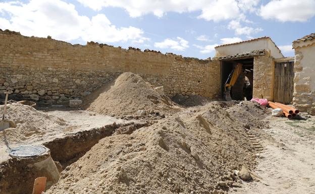 Al fondo, excavadora que desenterró los restos. 