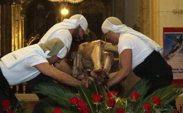 Los costaleros levantan al Cristo de la Esperanza. 