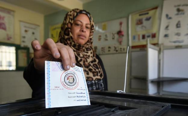 Una mujer deposita su voto en las elecciones de Egipto. 